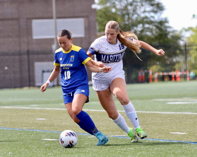 A Buccaneer shielding the ball from a Worcester State defender